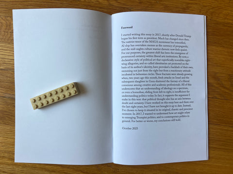 Open book with a beige plastic brick on a wooden surface